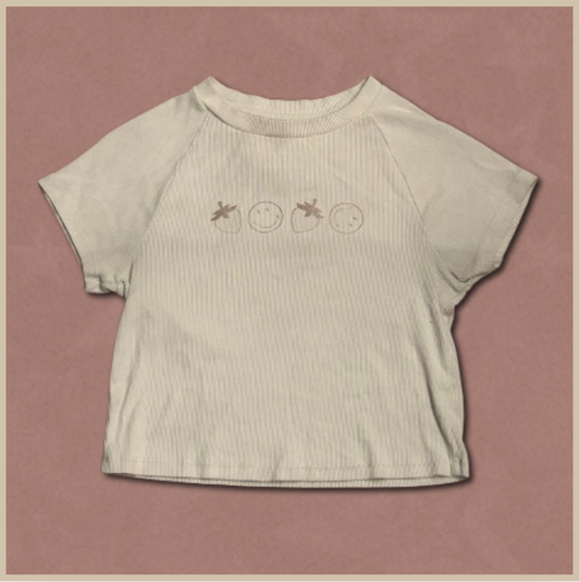 pale beige crop top with smiley/strawberry design