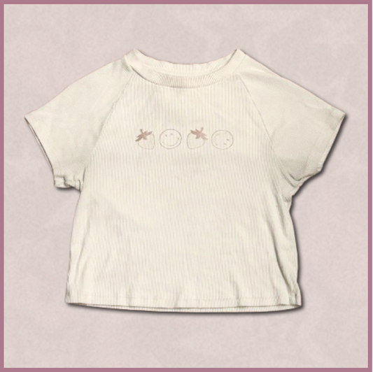 pale beige crop top with smiley/strawberry design